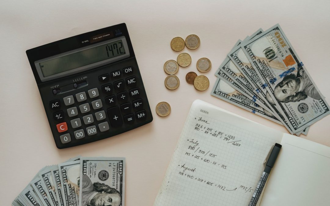 photo of calculator, documents, bills and coins