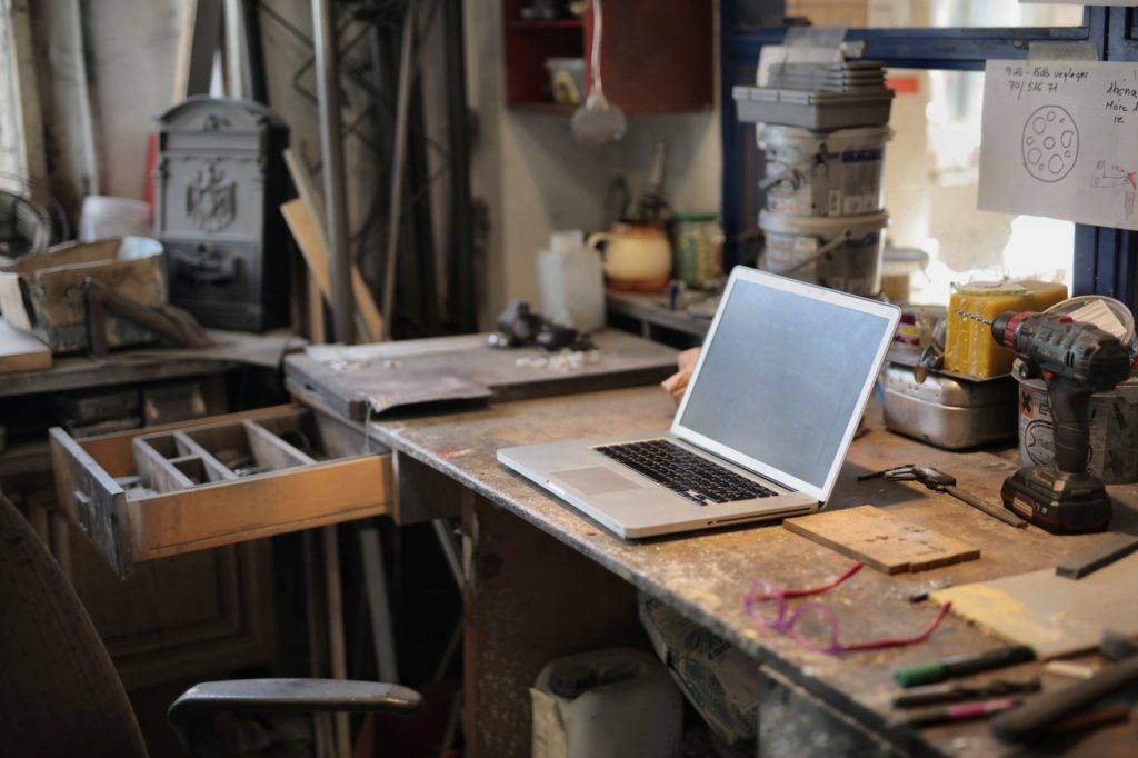photo of a laptop on a desk and a workshop