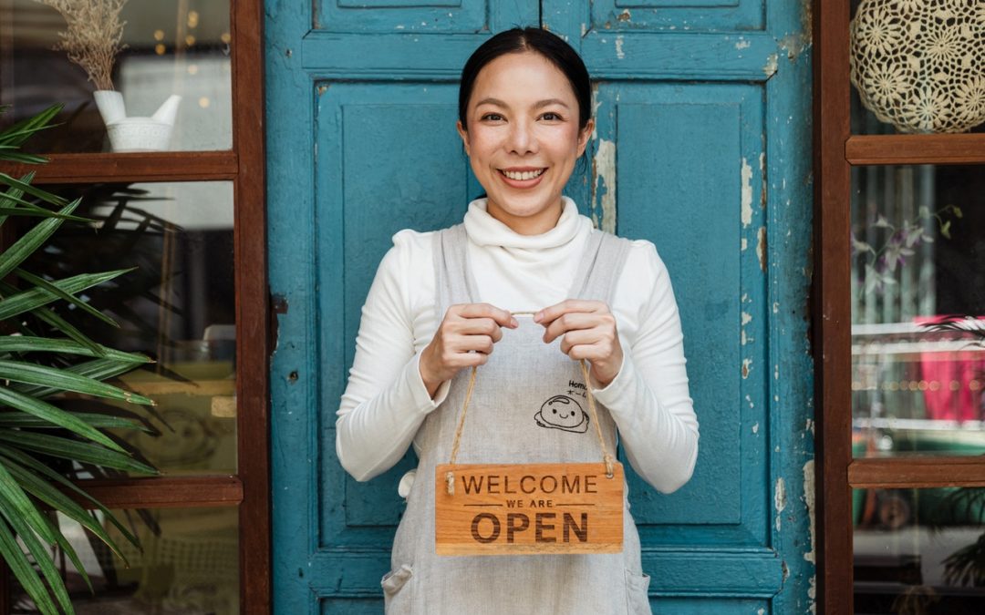 photo of woman holding an 'open' sign